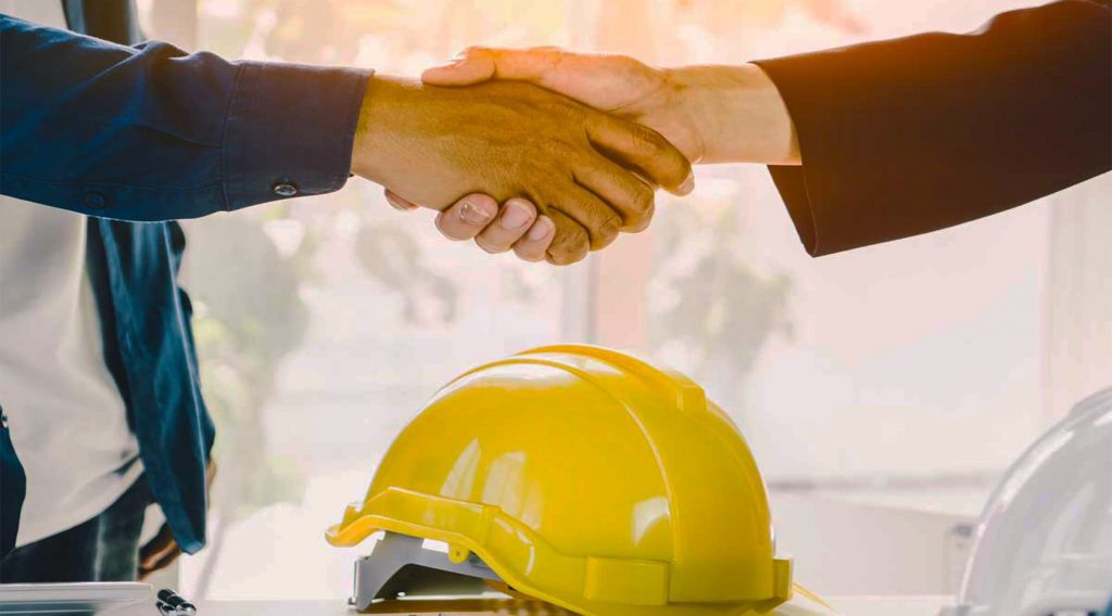 Successful deal, male architect shaking hands with client in construction site after confirm blueprint for renovate building.