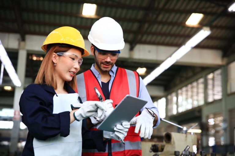 Supervisor and engineer wearing safety uniform and equipment discussion at work shop or factory